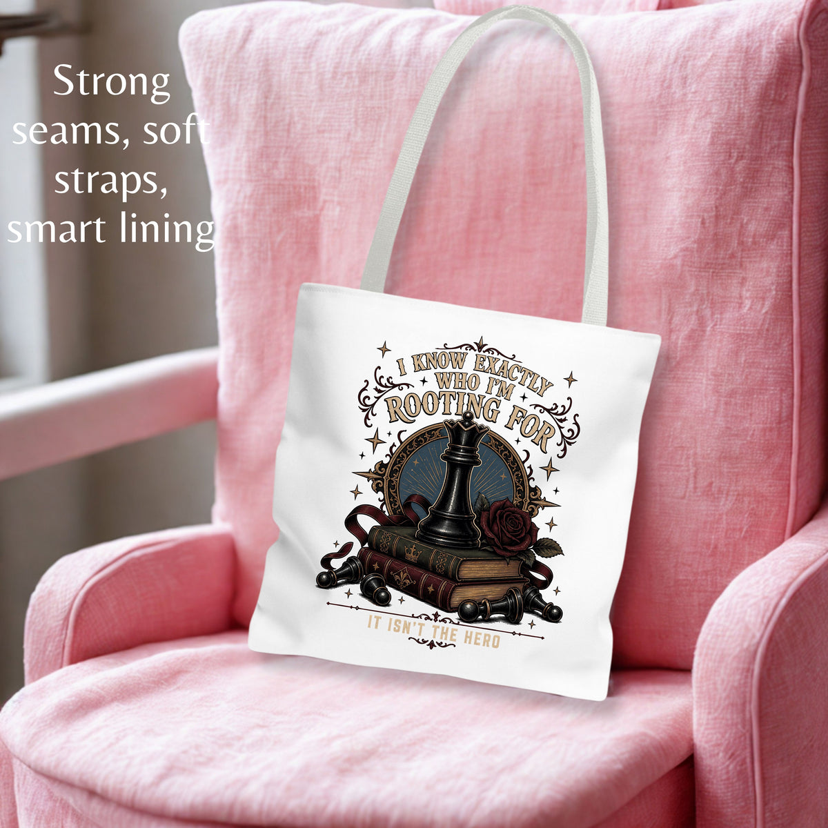 A white canvas tote bag with a graphic design of a chess piece, books, and roses, resting on a pink armchair. The text on the left highlights the bag's soft seams, straps, and smart lining.
