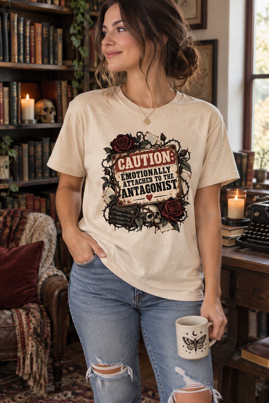 Dark romance readers, consider this your official warning. The “Caution: Emotionally Attached to the Antagonist” shirt features distressed vintage lettering, thorny vines, dark red roses, books, and gothic details for the reader who always chooses the villain. Wear this bookish tee to book club, bookstore trips, author events, or cozy reading days. It also makes a memorable gift for romantasy fans, morally gray character lovers, and romance readers who collect fictional red flags.