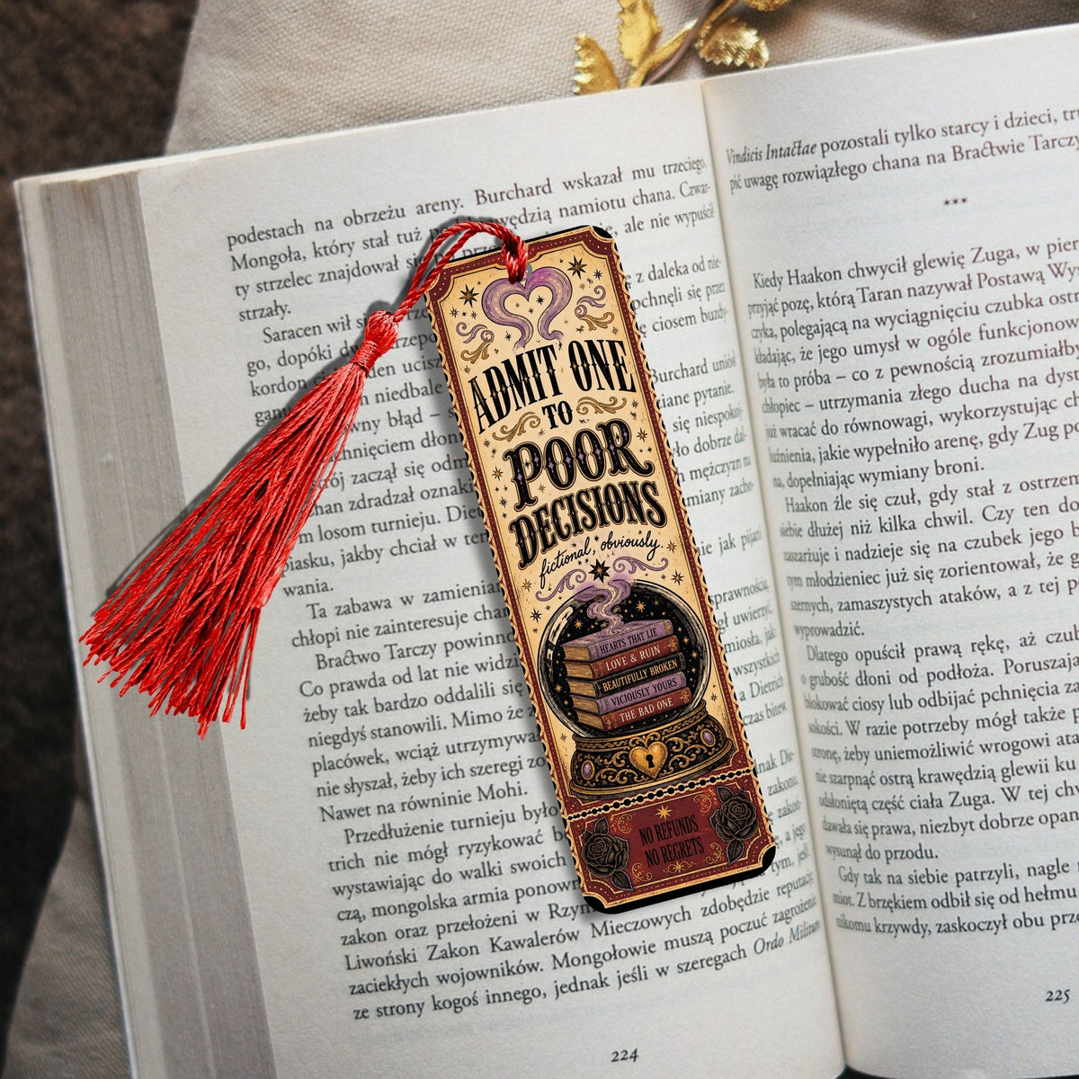 A novelty bookmark shaped like a vintage newspaper with the text 'LIMIT ON POOP DECISIONS' and a red tassel, resting on open book pages.