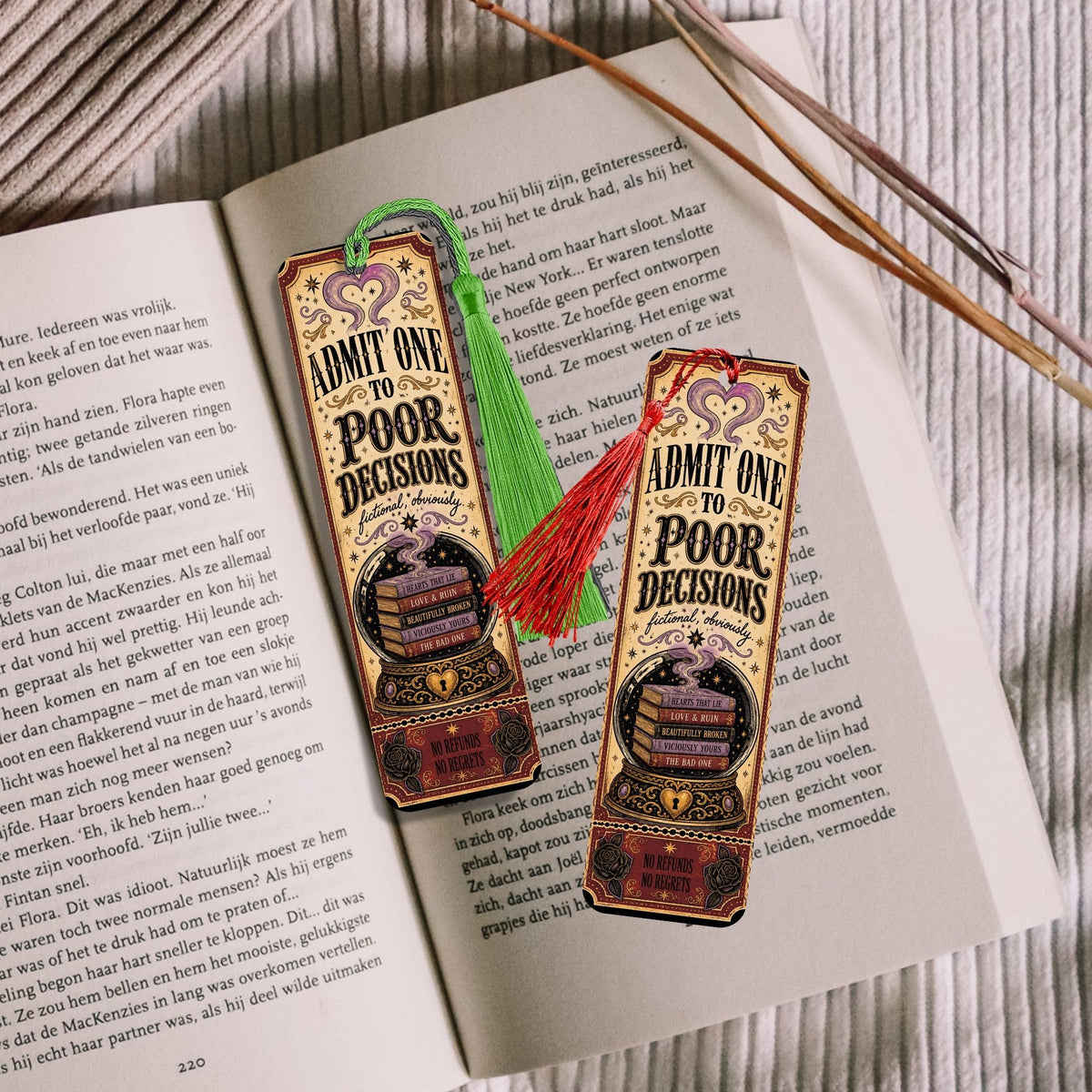 Two decorative bookmarks styled on an open book, featuring vintage ticket designs that read 'ADMIT ONE TO POOR DECISIONS' with a ticket illustration and tassels in green and red.