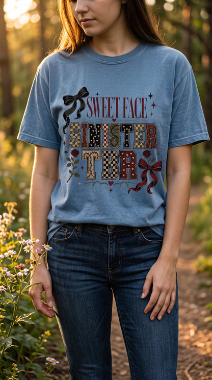 A bold bookish shirt for readers with a sweet style and a seriously sinister TBR. This Sweet Face Sinister TBR Shirt features vintage collegiate lettering, checkerboard details, roses, thorny vines, hearts, and bows in a moody burgundy, black, cream, and olive palette. Perfect for dark romance readers, romantasy fans, BookTok lovers, TBR addicts, and anyone who keeps adding “just one more book” to the pile. Save this for book lover outfit ideas, reader gifts, bookstore looks, and dark romance apparel.

#Boo