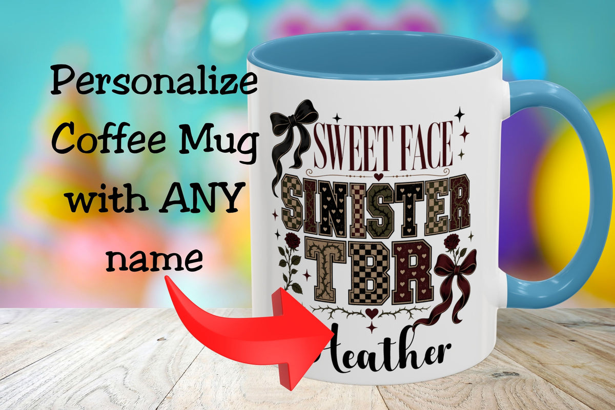 A white coffee mug with a blue handle and interior, featuring the text 'SWEET FACE SINISTER TDR Leather' in decorative lettering. The mug is shown on a wooden surface with a colorful blurred background, and text on the left reads 'Personalize Coffee Mug with ANY name' with a red arrow pointing to the mug.
