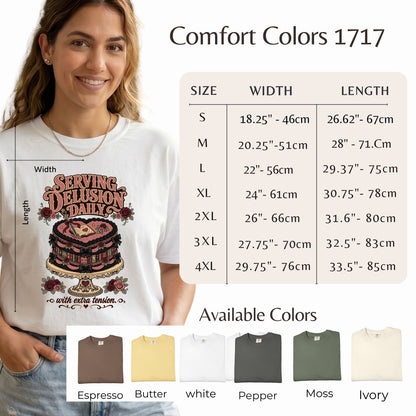 A woman wearing a white graphic T-shirt with a coffee cup design and the text 'SERVING DELUSIONS DAILY' is shown alongside a size chart for Comfort Colors 1717 and available color options at the bottom.