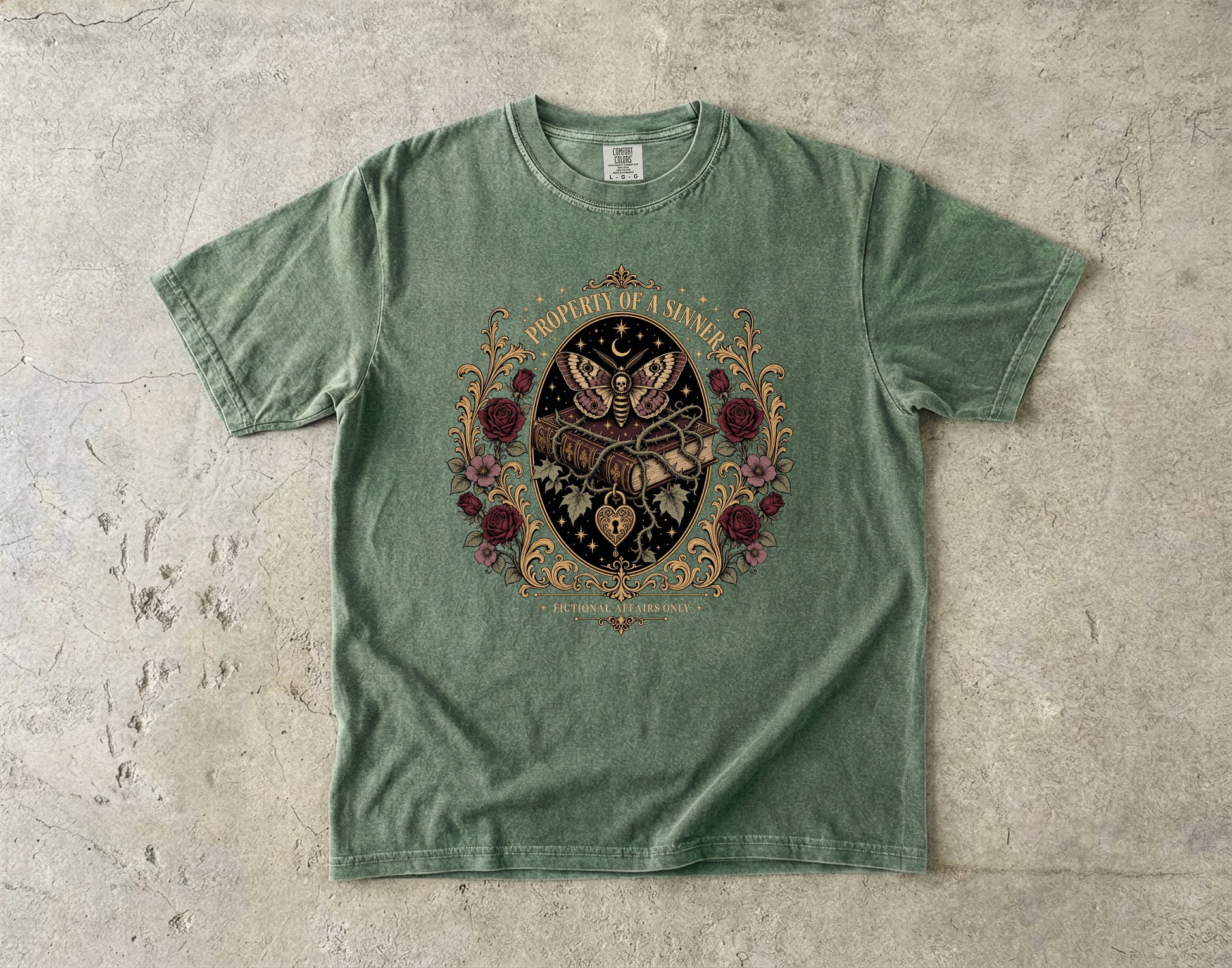 A sage green short-sleeve t-shirt with a detailed gothic graphic of a skeleton hand holding a dagger, surrounded by a butterfly, roses, and the text 'PROPERLY UNARMED' on a textured concrete background.