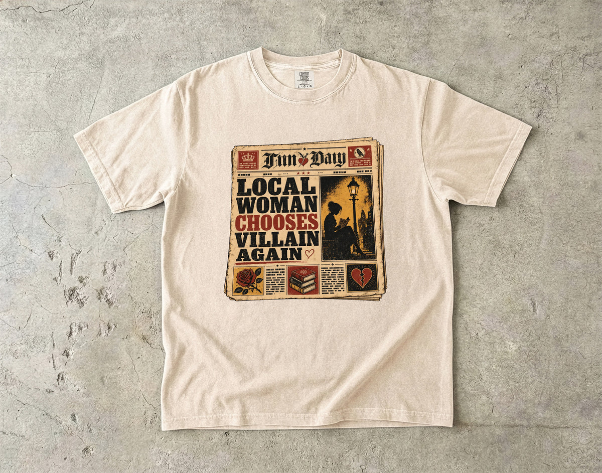 A cream-colored short-sleeve t-shirt with a vintage newspaper graphic on the front, laid flat on a textured gray concrete surface. The graphic is titled 'Fun's Day' and features the text 'LOCAL WOMAN CHOOSES VILLAIN AGAIN'.