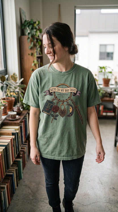 The keys to questionable fictional taste are officially on display. This vintage dark romance shirt features an antique keyring with a “Villains Are My Love Language” book, rose, ornate heart lock, celestial moon, and decorative dagger. Perfect for morally gray hero fans, romantasy readers, villain lovers, BookTok friends, and gothic book lovers. #DarkRomance #MorallyGray #BookishStyle #RomantasyReader #BookLoverShirt