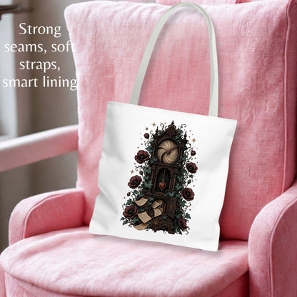 A white canvas tote bag with a gothic clock illustration, resting on a pink armchair. The text on the top left highlights its strong seams, soft straps, and smart lining.
