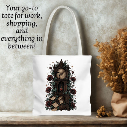 White canvas tote bag with a gothic illustration of a clockwork mechanism, roses, and a heart, displayed on a wooden surface against a textured gray wall with dried flowers and text overlay.