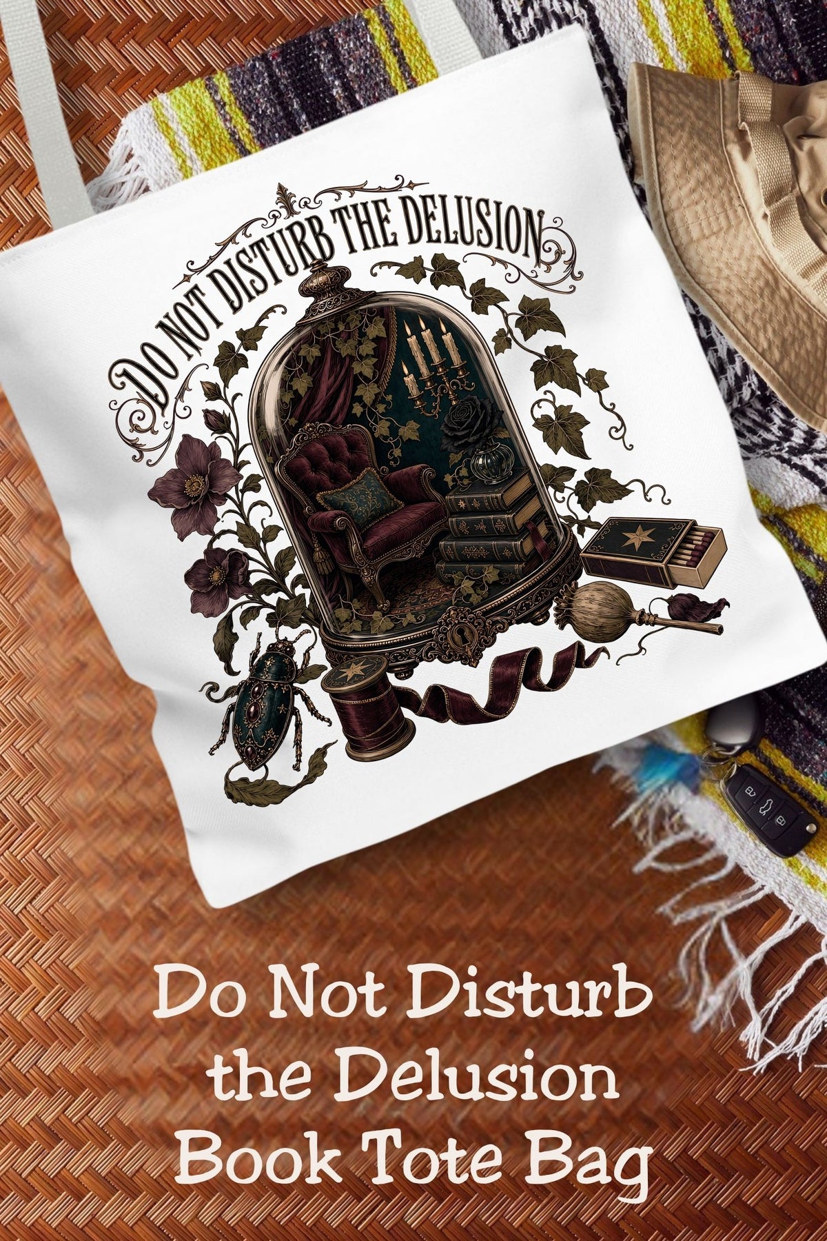 Physically here, mentally in a candlelit library. This “Do Not Disturb the Delusion” book tote features a miniature reading nook beneath a glass dome, surrounded by ivy, moody flowers, and burgundy ribbon. The 16 × 16-inch bag holds your current read and everyday essentials for library trips and bookstore browsing. A thoughtful gift for romantasy readers, dark academia fans, and book lovers who treasure uninterrupted reading time.