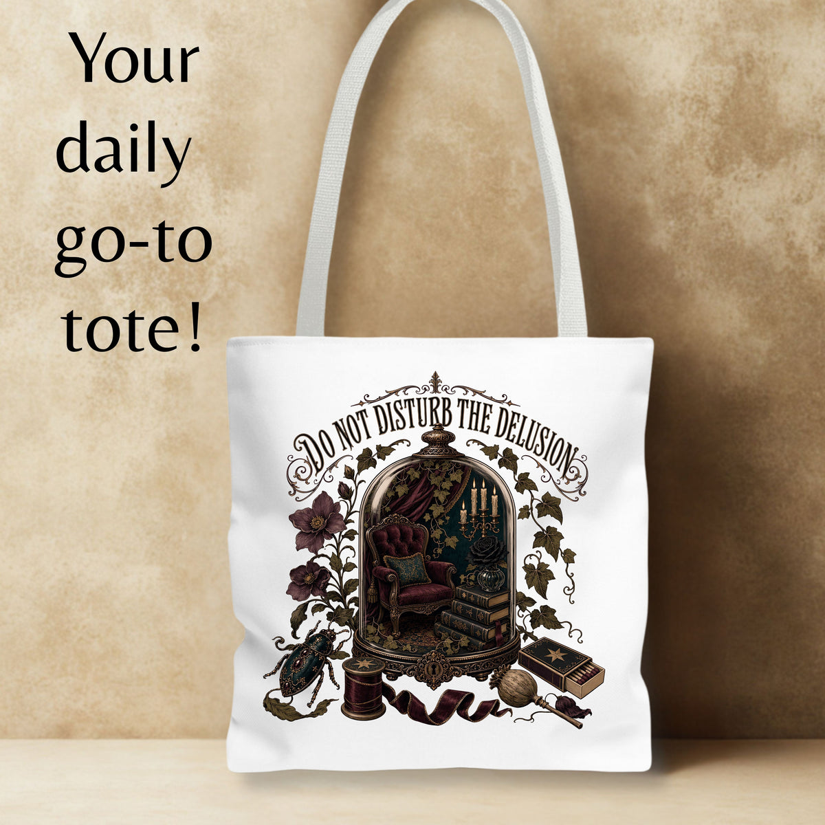 A white canvas tote bag with a gothic illustration of a miniature library under a glass dome and the text 'Do Not Disturb the Delusion.' It is shown against a textured beige background with promotional text on the left.