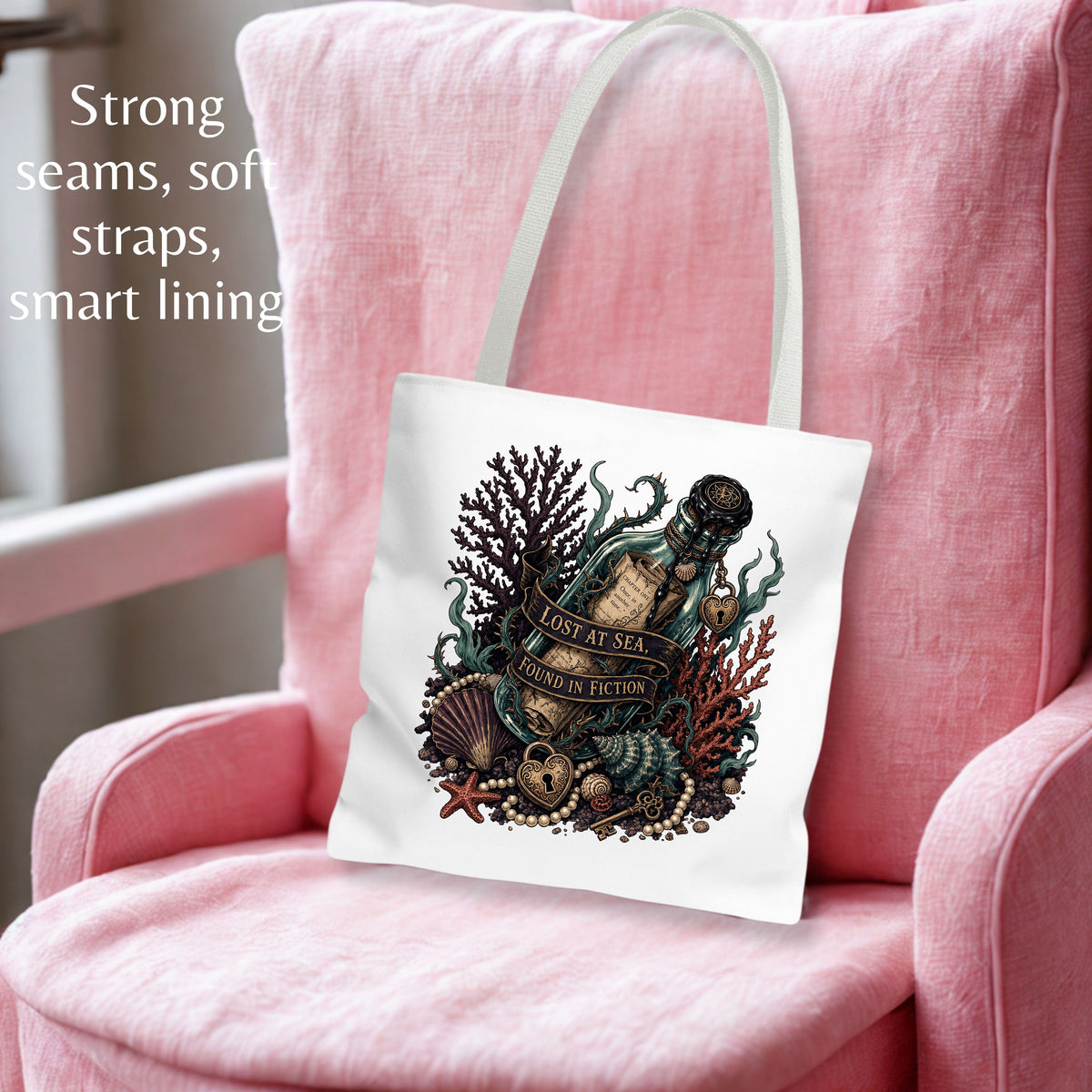 A white canvas tote bag with a detailed vintage-style ocean illustration, displayed on a pink armchair. The bag features a central graphic of a bottle, sea creatures, and the text 'LOST AT SEA.