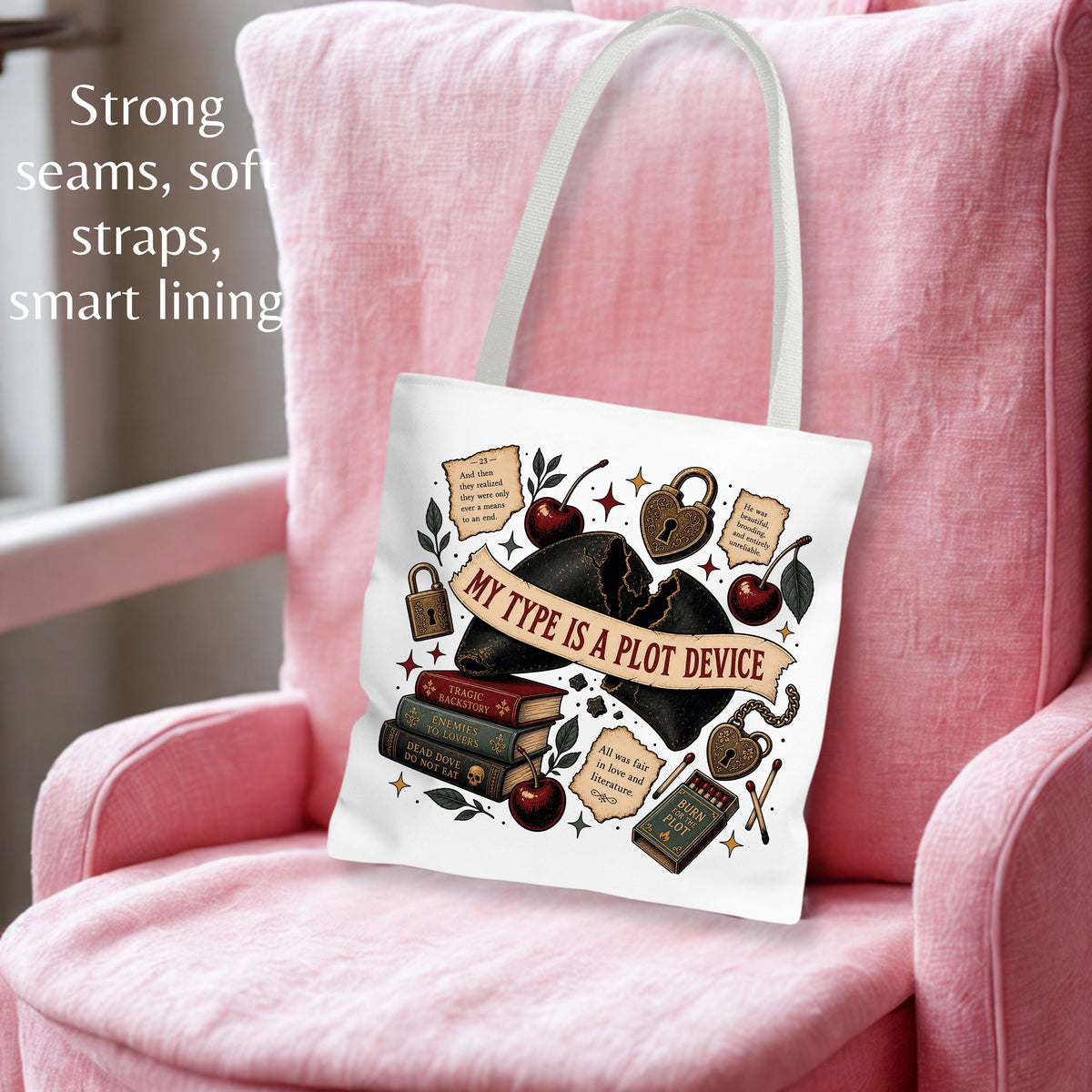 A white canvas tote bag with a vintage-style gothic illustration of books, cherries, and a banner reading 'MY TYPE IS A PLOT DEVICE,' displayed on a pink armchair. Text on the left highlights strong seams, soft straps, and smart lining.