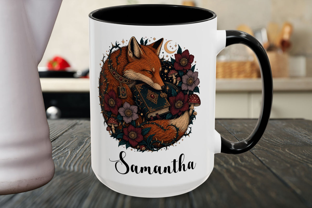 A white ceramic mug with a black handle and black interior, featuring a printed illustration of a sleeping fox surrounded by flowers and the name 'Samantha' in script, shown on a dark wooden tabletop.