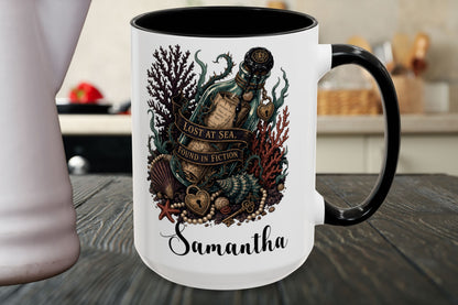 A white ceramic mug with a black handle and black interior, featuring a detailed graphic of an octopus inside a bottle labeled 'LOST AT SEA' surrounded by sea creatures, with the name 'Samantha' printed below, set on a dark wooden table.