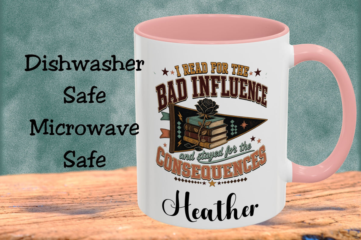 A white ceramic mug with a pink handle and interior, featuring a book-themed graphic and the text 'I Read For The Bad Influence and stayed for the Consequences' and the name 'Heather'. The mug sits on a wooden surface against a textured teal background, with text on the left reading 'Dishwasher Safe Microwave Safe'.