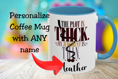 A white coffee mug with a blue handle and blue interior, featuring the printed phrase 'THE PLOT IS THICK. MY JUDGMENT IS THEN.