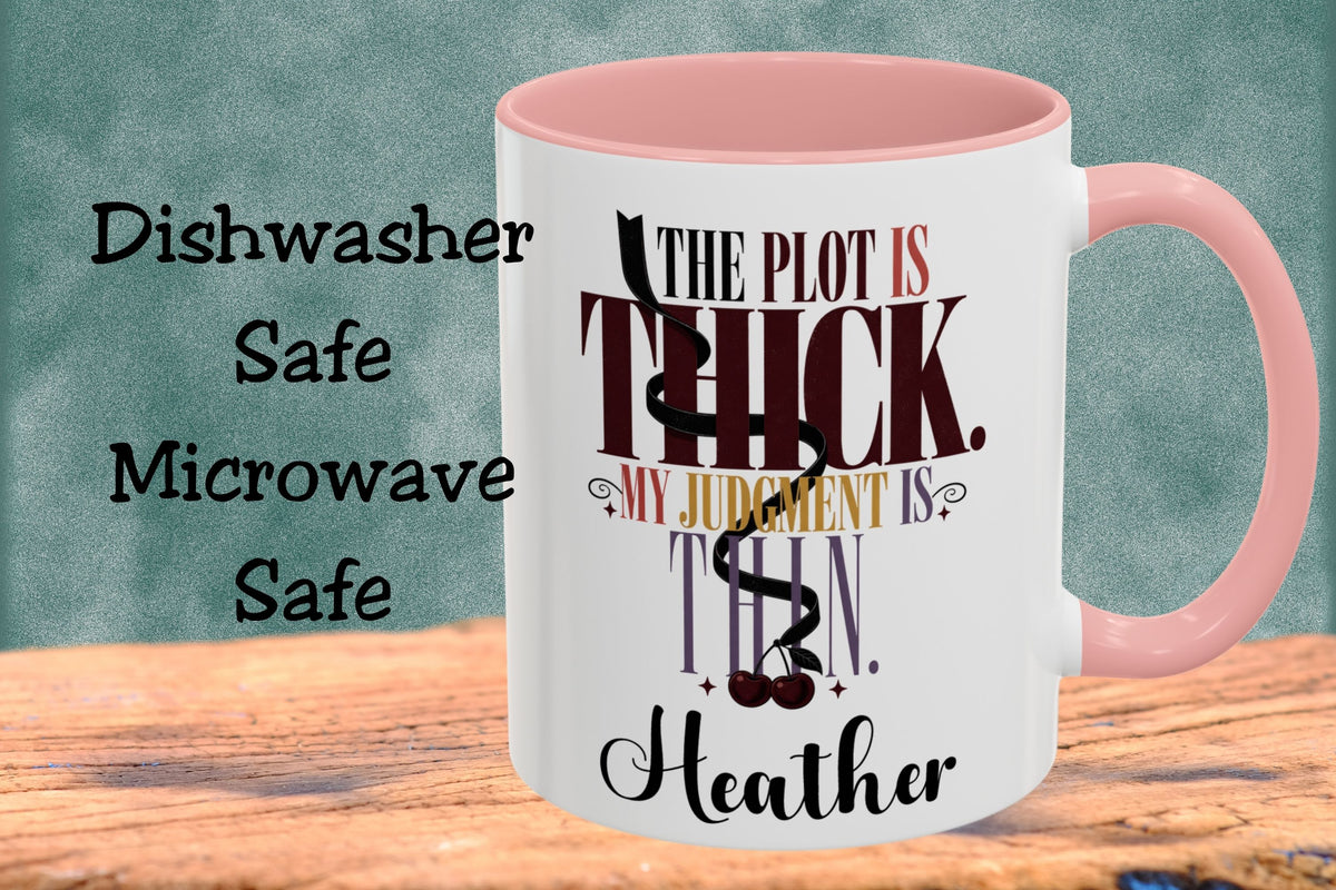 A white ceramic mug with a pink interior and handle, featuring the quote 'THE PLOT IS THICK. MY JUDGMENT IS THIN.