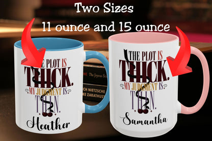 Two white ceramic mugs shown side by side with text reading 'Two Sizes 11 ounce and 15 ounce' and red arrows pointing to each mug. The left mug has a blue handle and interior, and the right mug has a pink handle and interior.