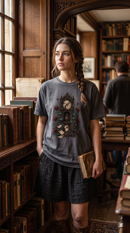 Lose track of time in your next favorite story with this gothic book lover shirt. The design features an ornate grandfather clock wrapped in ivy and burgundy flowers, complete with a heart-shaped pendulum and loose book pages spilling from its cabinet. Perfect for fantasy readers, dark academia lovers, writers, librarians, and anyone who would rather be wandering through an enchanted library. Available in Blue Jean, Moss, Pepper, Butter, Espresso, Ivory, and White. #BookLoverShirt #DarkAcademia #GothicStyle