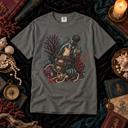 A dark gray graphic t-shirt featuring an underwater scene with a bottle, pearls, starfish, and coral, with the text 'LOST AT SEA.