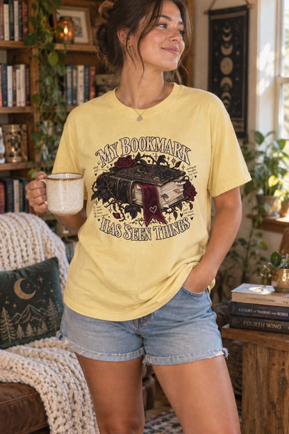 Your bookmark has been through the plot twists, late-night chapters, and scenes you immediately reread. This funny book lover shirt features antique books, burgundy roses, gothic botanical details, and a dramatic ribbon bookmark on a soft Pepper Comfort Colors tee. A fun gift for romance readers, fantasy fans, librarians, book club friends, and devoted bookworms. Perfect for reading days, bookstore visits, author events, and book club nights. Shop through the link in the first comment. #BookLoverShirt #Read