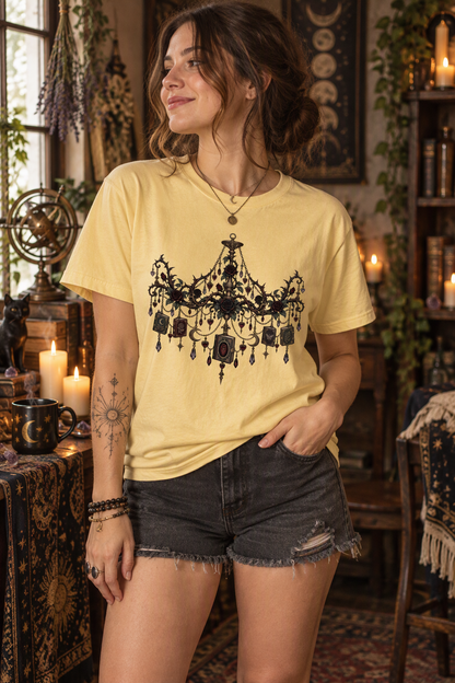 Shop this gothic book lover shirt featuring an ornate chandelier decorated with miniature books, dark roses, jewel drops, celestial charms, and antique-inspired details. This romantic dark-academia tee is perfect for book club meetings, bookstore trips, library visits, author events, and fantasy conventions. A distinctive gift for romance readers, romantasy fans, librarians, teachers, book besties, and lovers of gothic literary style.