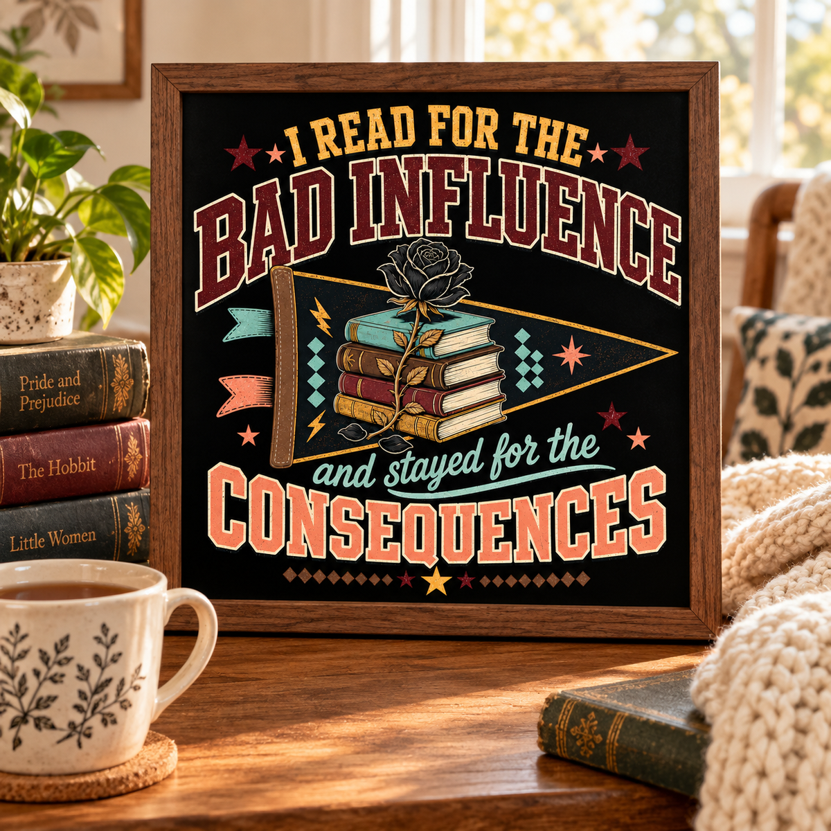 A framed decorative sign with a black background and bold retro text reading 'I READ FOR THE BAD INFLUENCE and stayed for the CONSEQUENCES,' surrounded by books, a mug, and a cozy indoor setting.