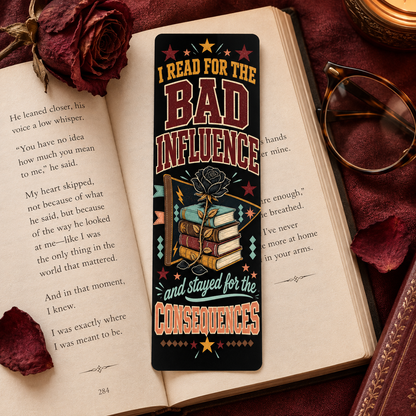 A rectangular book bookmark with a dark background and a colorful graphic of stacked books tied with a rose, placed on an open book. The bookmark features the text 'I READ FOR THE BAD INFLUENCE and stayed for the CONSEQUENCES' with stars and decorative accents.