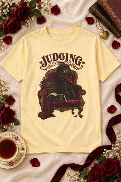 Judging your book taste—and your favorite fictional red flags. 📚 This dark romance Comfort Colors shirt features an elegant black poodle lounging in a burgundy velvet chair with books, roses, and vintage gothic details. A funny gift for romance readers, BookTok friends, poodle lovers, librarians, and book-club members who always have opinions about the TBR.

#DarkRomance #BookLoverGift #BookTokStyle
